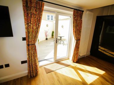 A living room with a patio door and curtains at Newly Refurbished Cottage, sleeping 4 and Central Berwick-Upon-Tweed