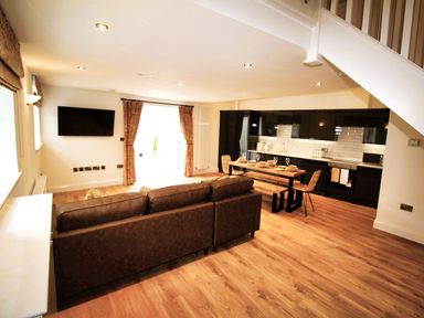 A living room and kitchen area with a sofa and dining table at Newly Refurbished Cottage, sleeping 4 and Central, Berwick-Upon-Tweed