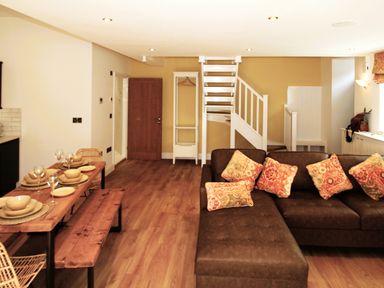 A living room with a sofa and dining table at Newly Refurbished Cottage, sleeping 4 and Central