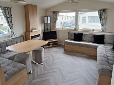A living room with a sofa, coffee table, and television at Golden Sands 3-Bed Caravan, Parking and Pet Friendly, Towyn