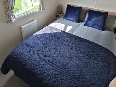 A bedroom with a bed and pillows at Golden Sands 3-Bed Caravan, Parking and Pet Friendly in Towyn