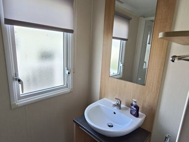 A bathroom with a sink and a mirror at Golden Sands 3-Bed Caravan, Parking and Pet Friendly, Towyn