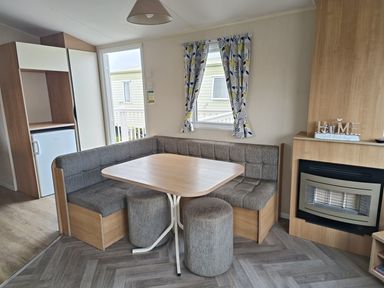 A dining area with a table and seating at Golden Sands 3-Bed Caravan, Parking and Pet Friendly, Towyn