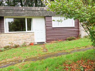 An outdoor view of a building with a door and windows at Villa 12 near Camelford