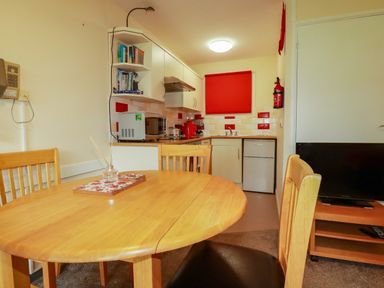 A kitchen with dining table and chairs at Villa 12 near Camelford