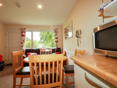 A dining room with a table and chairs at Villa 12 near Camelford