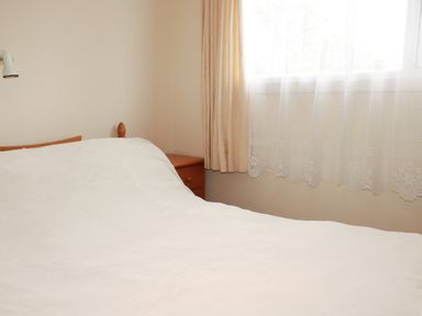 A bedroom with a bed and nightstand at Villa 12 near Camelford