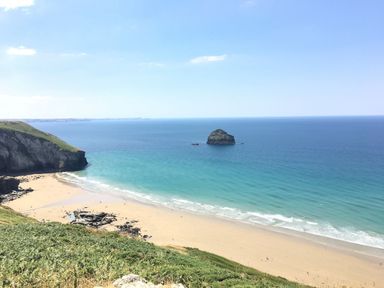 A beach with sand and rock formations near the ocean at Villa 12 near Camelford