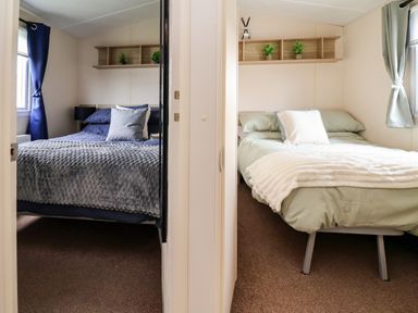 A bedroom with two beds and shelves at B54