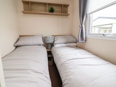 A bedroom with two beds and a lamp at B54