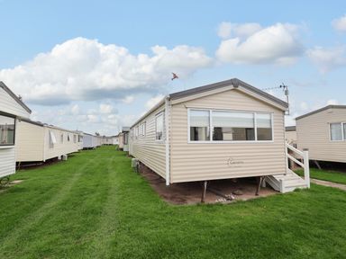 Mobile homes lined along a grassy pathway in an outdoor area at B54