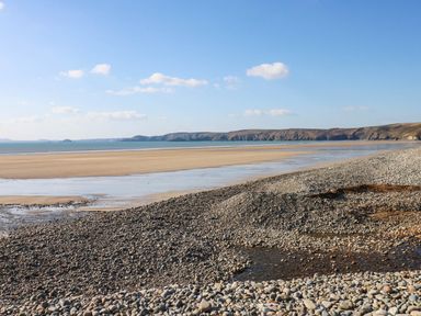 A beach with rocks and water at Seascape in Haverfordwest