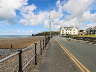 A beach view with a road and building at Seascape in Haverfordwest