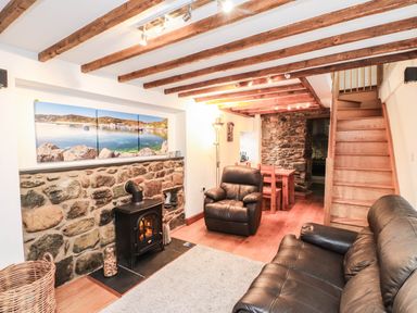A living room with a sofa and armchair at 2 bed Criccieth