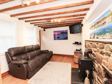 A living room with a sofa and television at 2 bed Criccieth