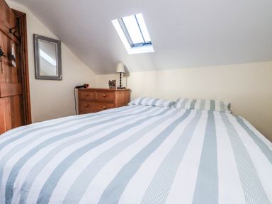 A bedroom with a bed and dresser at 2 bed Criccieth