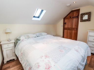 A bedroom with a bed and furniture at 2 bed Criccieth