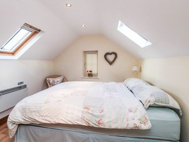 A bedroom with a bed and window at 2 bed Criccieth