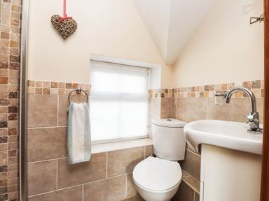 A bathroom with a toilet and sink at 2 bed Criccieth