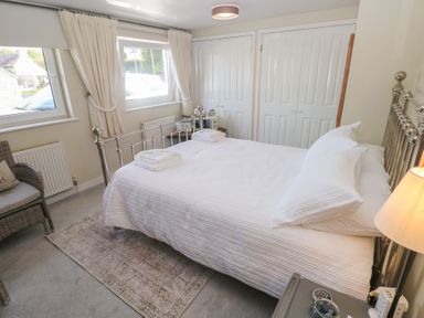 A bedroom with a double bed and a chair at Hafan y Tyddyn