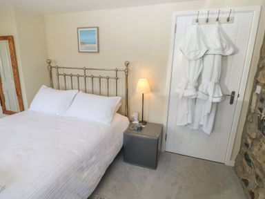A bedroom with a bed and bedside table at Hafan y Tyddyn