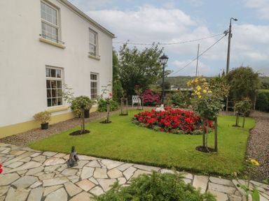 A garden with flowers and a path at Bruckless Rest Fine Country Dining B&amp;B in Bruckless