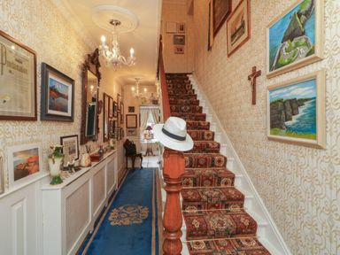 A hallway with a staircase and wall art at Bruckless Rest Fine Country Dining B&amp;B Bruckless