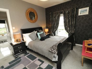 A bedroom with a bed and mirror at Bruckless Rest Fine Country Dining B&amp;B Bruckless