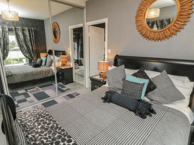 A bedroom with a bed and mirror at Bruckless Rest Fine Country Dining B&amp;B, Bruckless