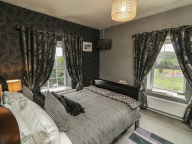 A bedroom with a bed and windows at Bruckless Rest Fine Country Dining B&amp;B in Bruckless