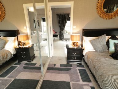 A bedroom with two beds and a view of a bathroom at Bruckless Rest Fine Country Dining B&amp;B Bruckless