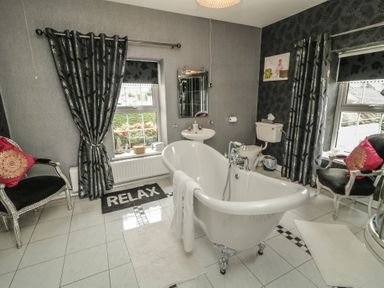 A bathroom with a bathtub and toilet at Bruckless Rest Fine Country Dining B&amp;B in Bruckless
