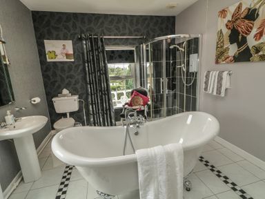 A bathroom with a bathtub and shower enclosure at Bruckless Rest Fine Country Dining B&amp;B, Bruckless