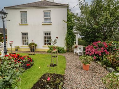 A garden with flowers and a bench at Bruckless Rest Fine Country Dining B&amp;B in Bruckless