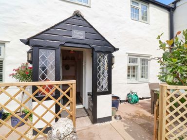 An entrance with a door and sign at Myrtle Cottage in Lynmouth