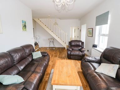 A living room with sofas and a coffee table at Doughbeg Beach Cottage