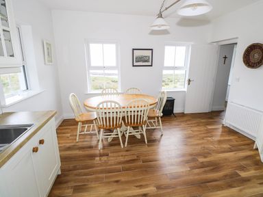 A dining room with a table and chairs at Doughbeg Beach Cottage