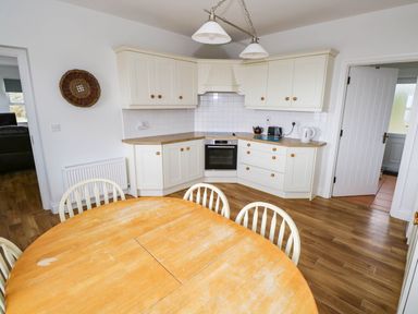 A kitchen with a round table and chairs at Doughbeg Beach Cottage