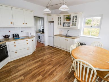 A kitchen with a table and chairs at Doughbeg Beach Cottage
