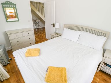 A bedroom with a bed and dresser at Doughbeg Beach Cottage