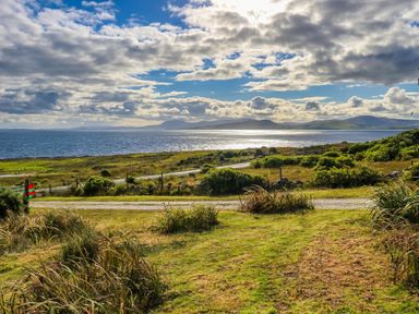 A scenic view of the ocean and hills at Doughbeg Beach Cottage