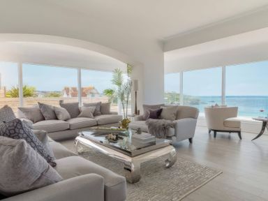 A living room with a sofa, armchair, and coffee table at By The Sea in Newquay