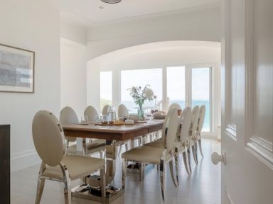 A dining room with a large table and chairs at By The Sea in Newquay