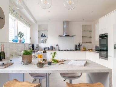 A kitchen with modern appliances and an island at By The Sea in Newquay