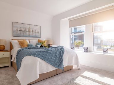 A bedroom with a bed and bedside tables at By The Sea in Newquay