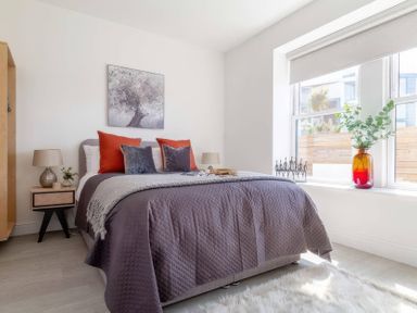 A bedroom with a bed and nightstand at By The Sea Newquay