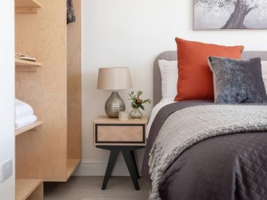 A bedroom with a bed and bedside table at By The Sea in Newquay