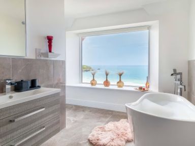 A bathroom with a bathtub and sink at By The Sea in Newquay