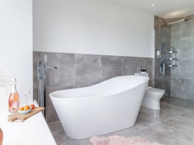 A bathroom with a bathtub and toilet at By The Sea in Newquay