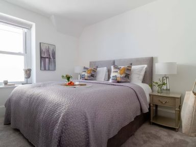 A bedroom with a bed and bedside table at By The Sea in Newquay